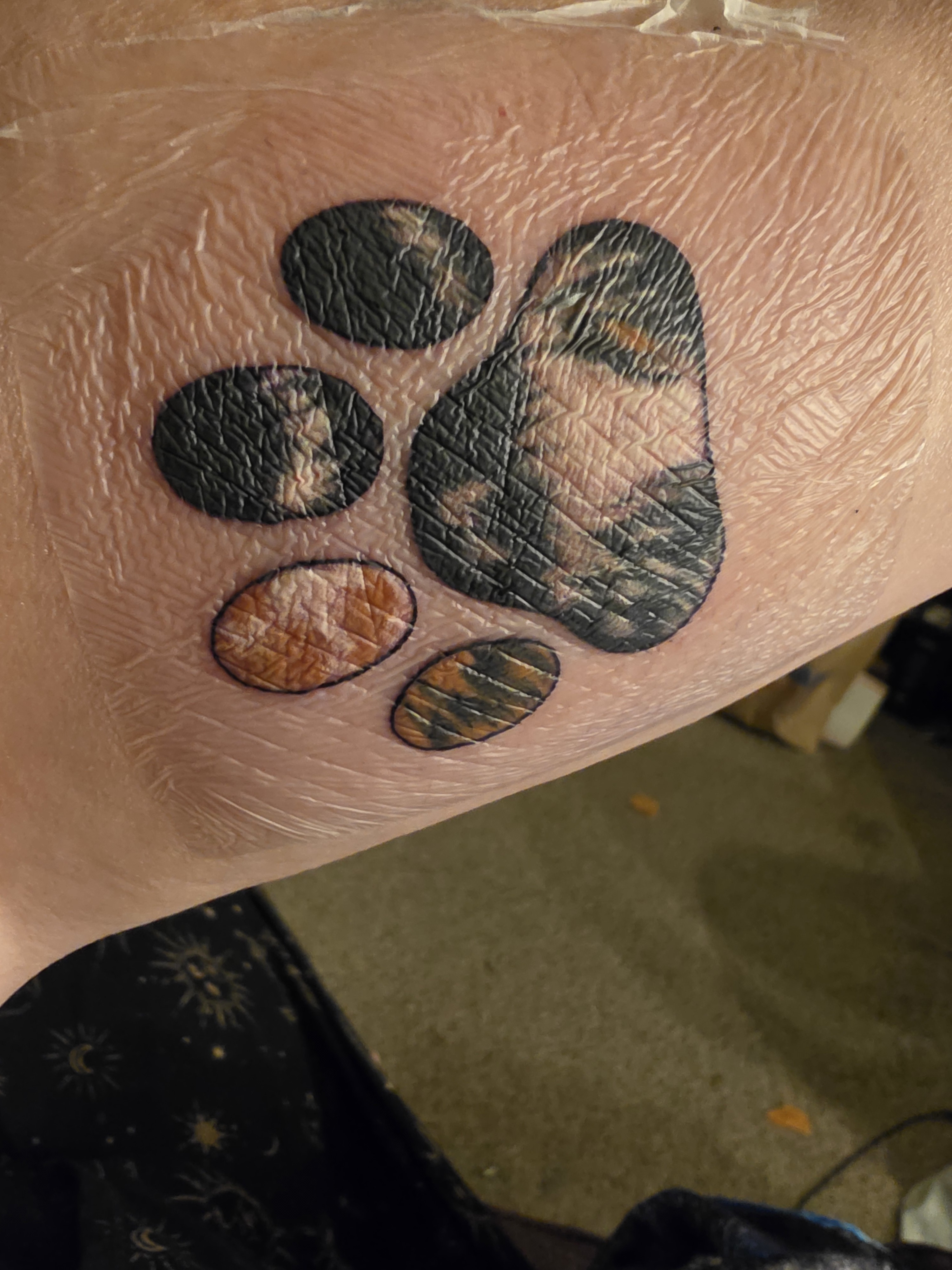 Tattoo og a paw print filled with the mottled calico pattern of my late cat 